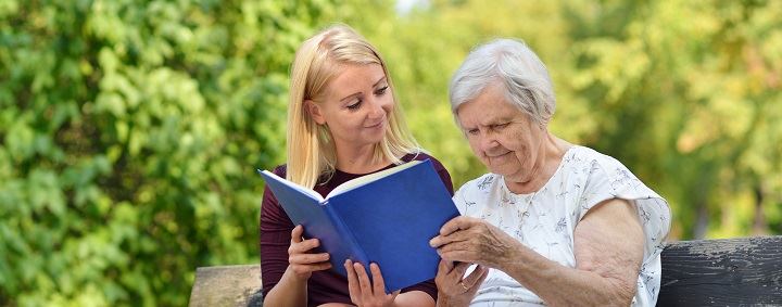 opiekunka czyta starszej osobie